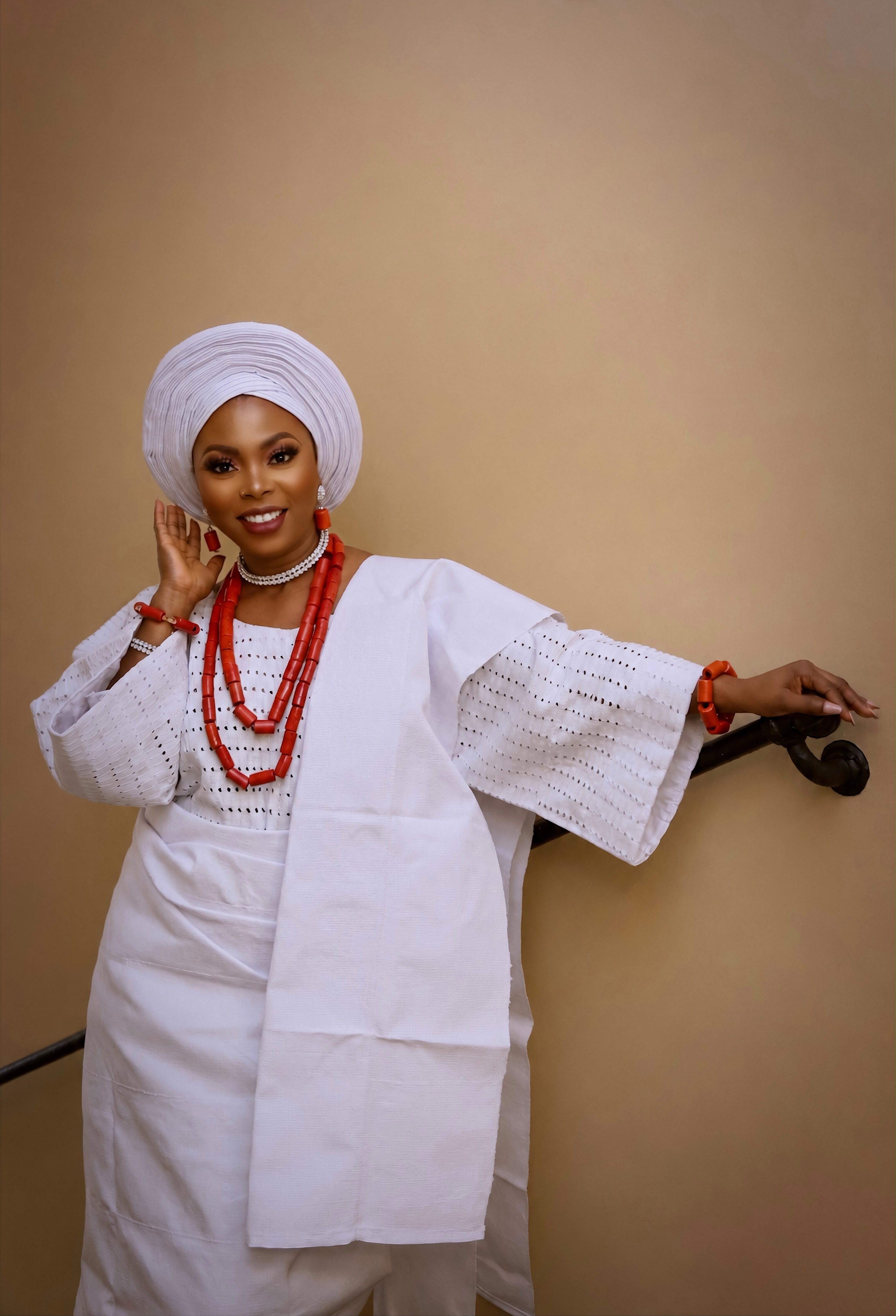 Woman in deep purple and gold Aso Oke with sculptural gele