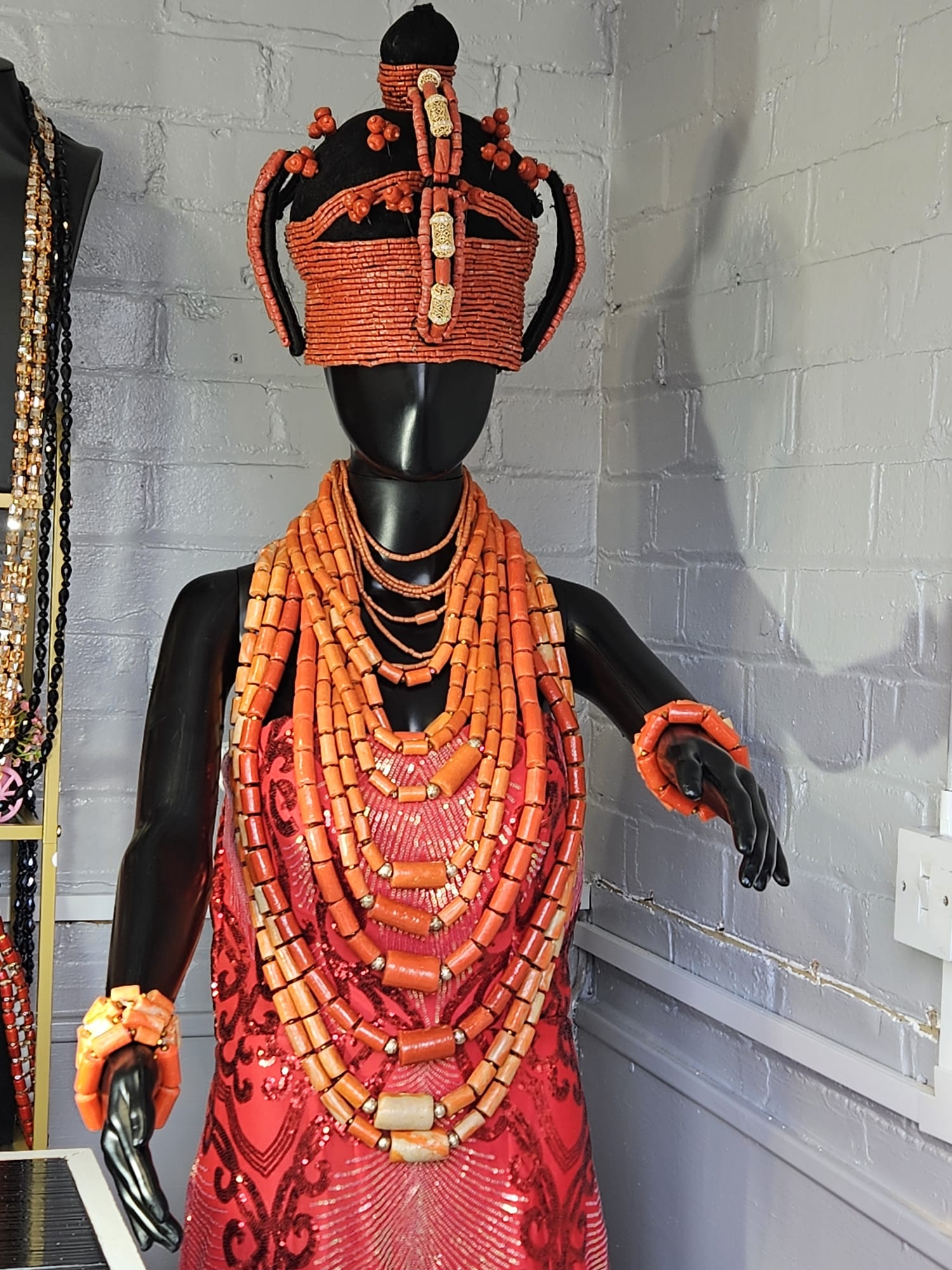 Ornate coral bead crown headpiece on a stand