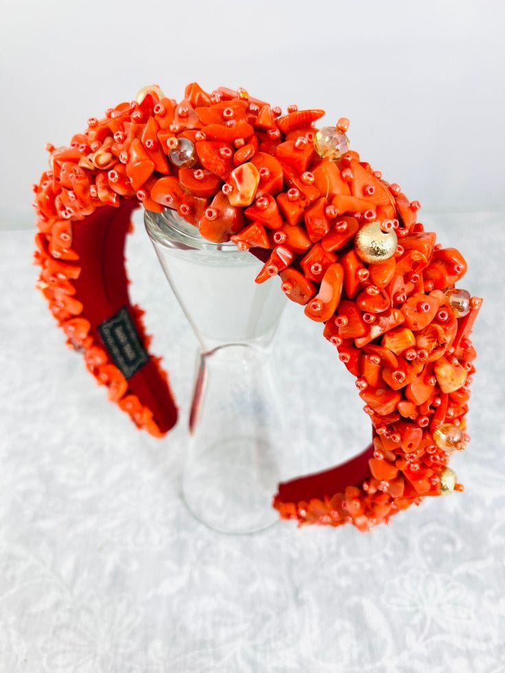 Ornate coral bead crown headpiece on a stand
